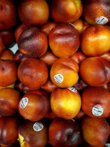A vibrant display of fresh peaches at a market, showcasing their bright colors.