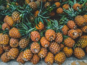 A vibrant display of ripe pineapples at a tropical outdoor market, showcasing freshness.