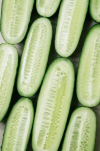 Vibrant close-up of sliced cucumbers, showcasing fresh green color and visible seeds. Perfect for healthy lifestyle promotion.